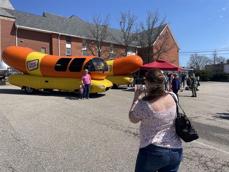 Folks pose in front of a rare appearance of two of the Oscar Mayer Wienermobile in Medina, Ohio, for the total eclipse. There are six total Wienermobiles in the world.
