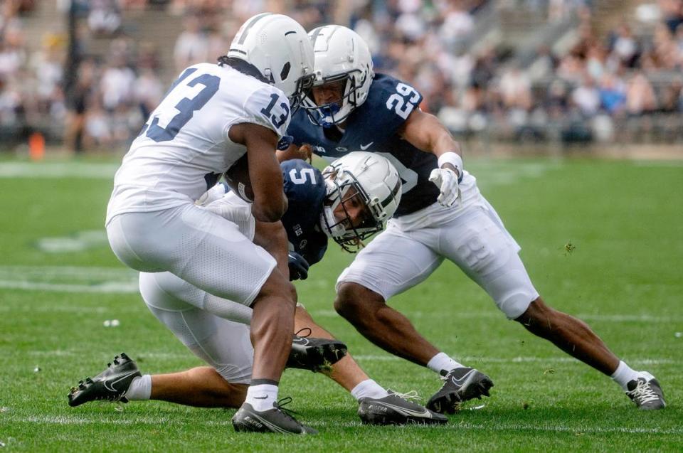 Cornerbacks Cam Miller and Storm Duck try to stop ball carrier Cristian Driver during the Penn State Blue-White game on Saturday, April 15, 2023.