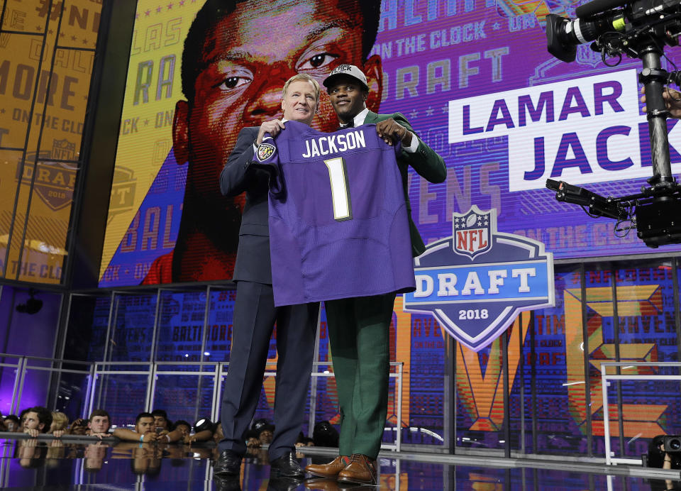 Commissioner Roger Goodell, left, presents Louisville's Lamar Jackson with his Baltimore Ravens jersey during the first round of the NFL football draft, Thursday, April 26, 2018, in Arlington, Texas. (AP Photo/David J. Phillip)