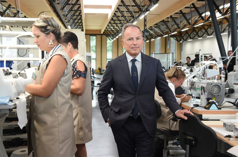 El CEO de Louis Vuitton, Michael Burke, posa junto a empleados que cosen cuero durante la inauguración de la fábrica de Louis Vuitton en Beaulieu-sur-Layon, oeste de Francia, el 5 de septiembre de 2019