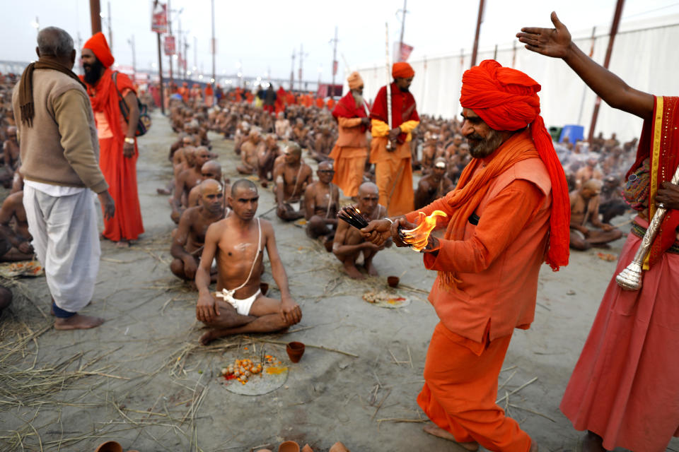 In this Jan. 27, 2019, photo, Hindu men perform prayers for becoming Naga Sadhus or naked holy men at Sangam, the confluence of three holy rivers during the Kumbh Mela or pitcher festival in Prayagraj Uttar Pradesh state, India. At every Kumbh, including this year's, thousands of devotees were initiated into the reclusive sect of the Naga Sadhus, naked, ash-smeared cannabis-smoking Hindu warriors and onetime-armed defenders of the faith who for centuries have lived as ascetics in jungles and caves. (AP Photo/ Rajesh Kumar Singh)