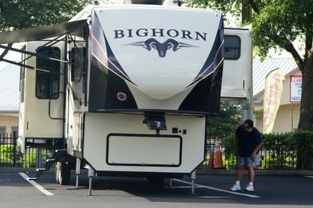 A man looks at an RV for sale at a dealership in Dover