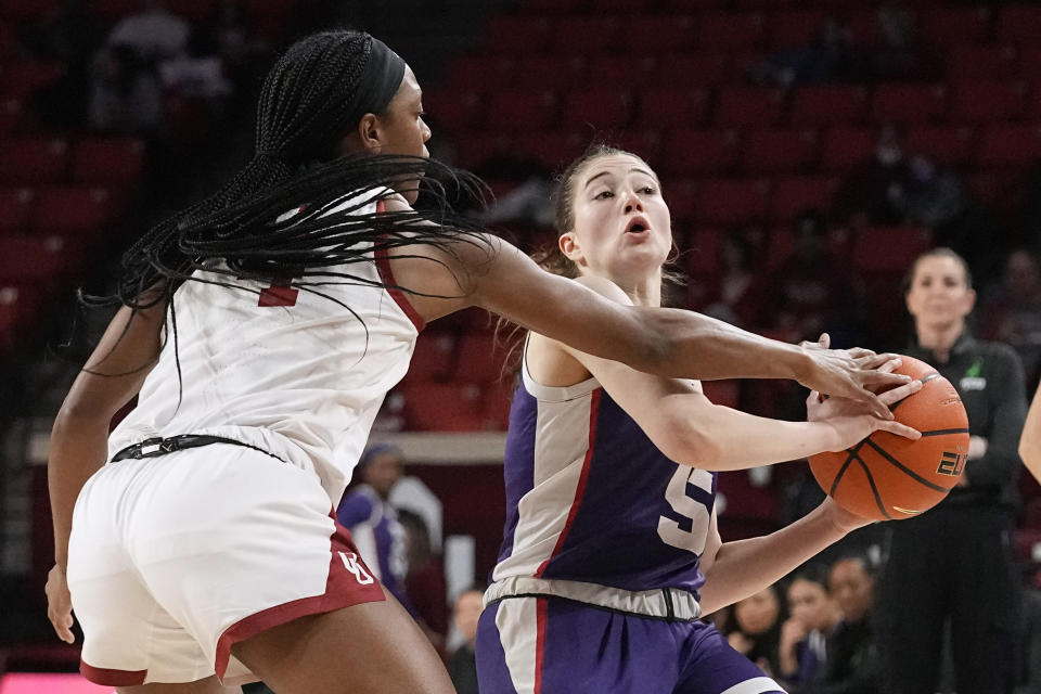 Oklahoma guard Kennady Tucker, left, reaches for the ball held by TCU guard Emily Fisher (5) in the first half of an NCAA college basketball game Tuesday, Jan. 31, 2023, in Norman, Okla. (AP Photo/Sue Ogrocki)