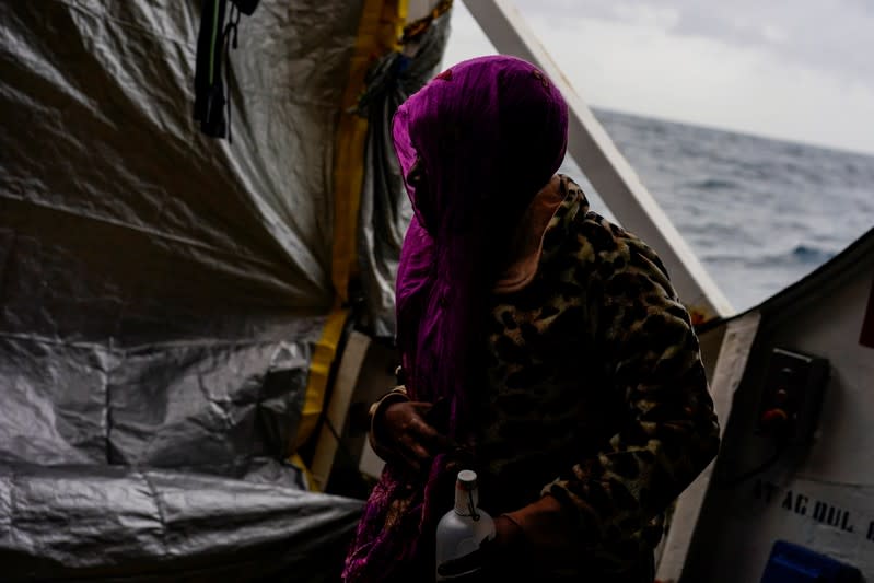 A migrant walks on board a NGO Proactiva Open Arms rescue boat in the central Mediterranean Sea