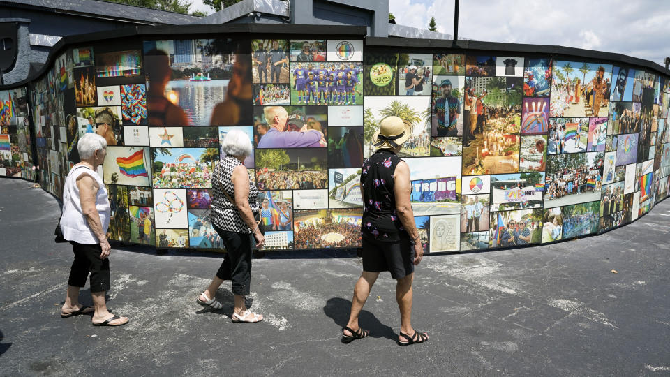 Visitors pay tribute to the outdoor display at the Pulse nightclub memorial Friday, June 11, 2021, in Orlando, Fla. Saturday will mark the fifth anniversary of the mass shooting at the site.(AP Photo/John Raoux)