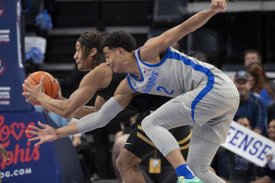 Vanderbilt guard Jordan Williams, back, drives to the basket defended by Memphis forward Nick Jourdain (2) during the first half of an NCAA college basketball game Saturday, Dec. 23, 2023, in Memphis, Tenn. (AP Photo/Nikki Boertman)