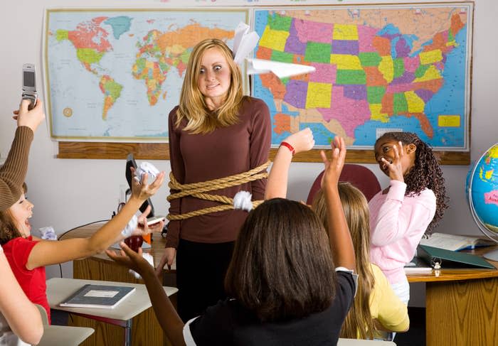 A teacher tied up with kids throwing things at her