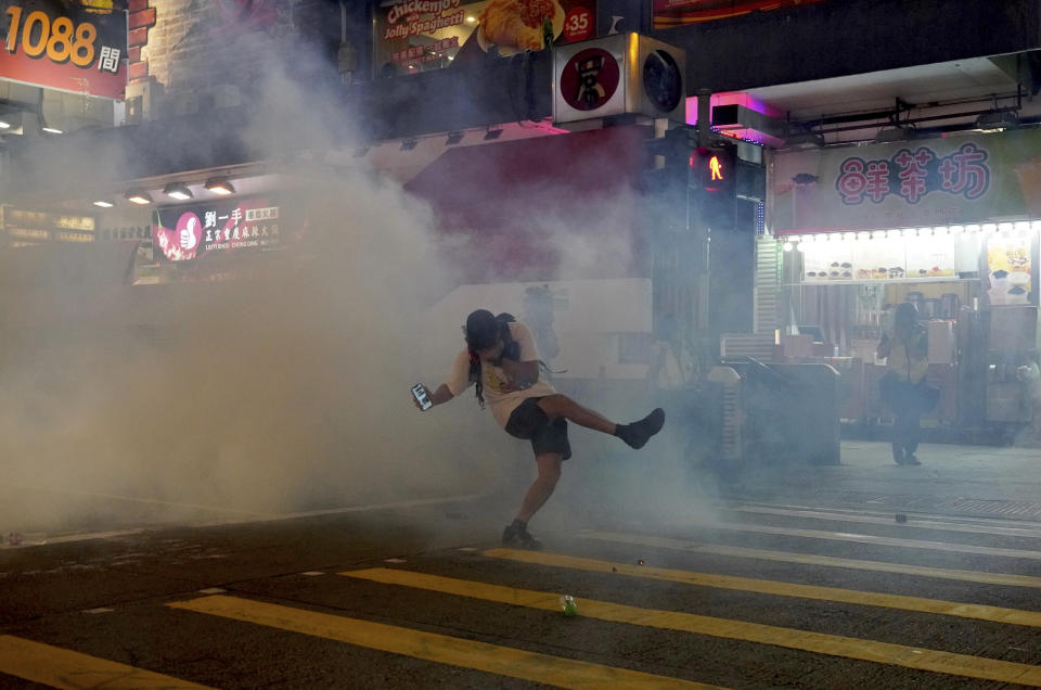 A protester reacts to tear gas during a confrontation with police in Hong Kong on Sunday, Oct. 27, 2019. Hong Kong police fired tear gas Sunday to disperse a rally called over concerns about police conduct in monthslong pro-democracy demonstrations, with protesters cursing the officers and calling them "gangster cops." (AP Photo/Vincent Yu)