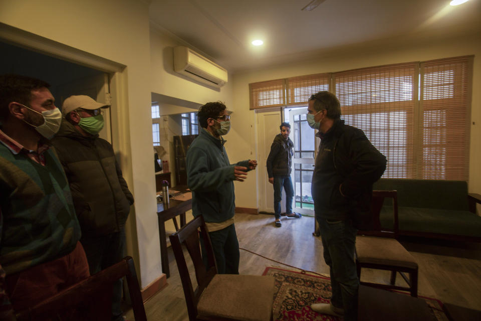 Agence France-Presse’s Kashmir correspondent Parvaiz Bukhari, centre, talks to his colleagues after National Investigation Agency personnel searched his premises on the outskirts of Srinagar, Indian controlled Kashmir, Wednesday, Oct. 28, 2020. (AP Photo/Mukhtar Khan)
