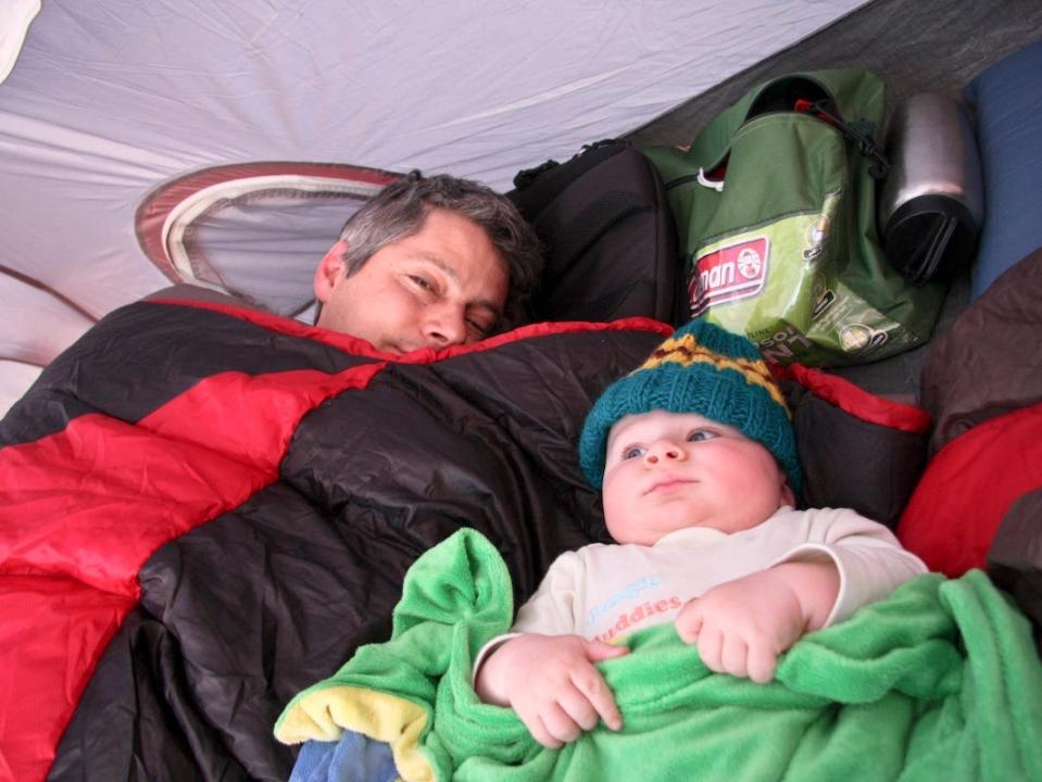 A father and son in their bed while camping.
