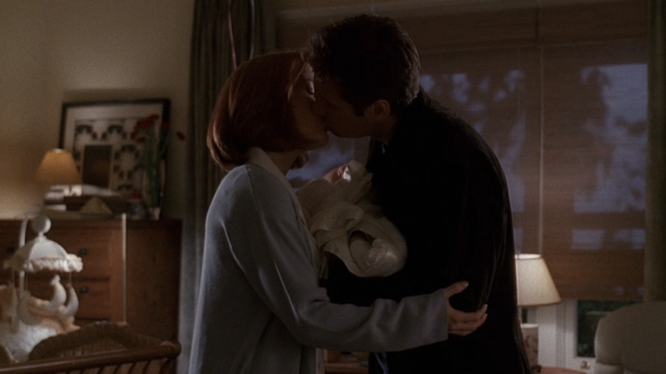 Scully and Mulder kissing over baby William in The X-Files' 