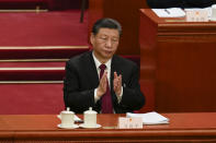 Chinese President Xi Jinping applauds during the opening session of the National People's Congress (NPC) at the Great Hall of the People in Beijing, China, Tuesday, March 5, 2024. (AP Photo/Ng Han Guan)