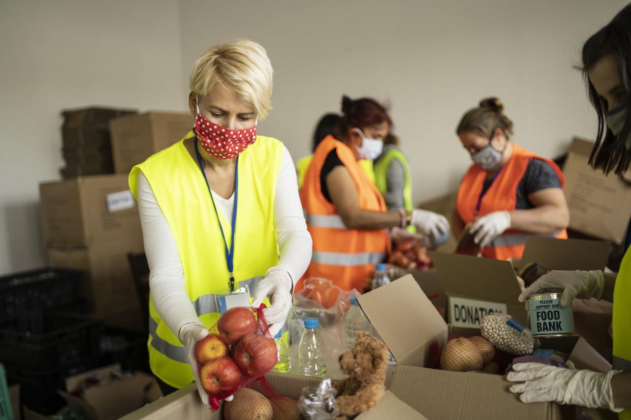 Female volunteer collecting food for donation in a homeless shelter