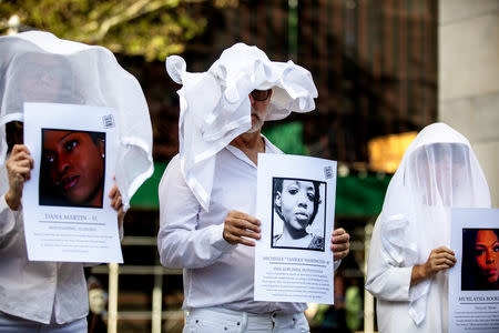 Transgender rights activists hold pictures of transgender women who were killed as they protest the recent killings of three transgender women, Muhlaysia Booker, Claire Legato, and Michelle Washington, during a rally at Washington Square Park in New York, U.S., May 24, 2019. REUTERS/Demetrius Freeman
