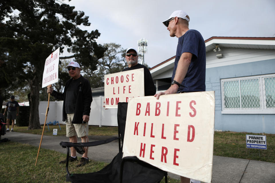 Anti-abortion rights activists stand outside of the Bread and Roses Woman's Health Center, a clinic that provides abortions while women arrive to receive patient care in Clearwater, Florida, U.S. February 11, 2023.  REUTERS/Octavio Jones