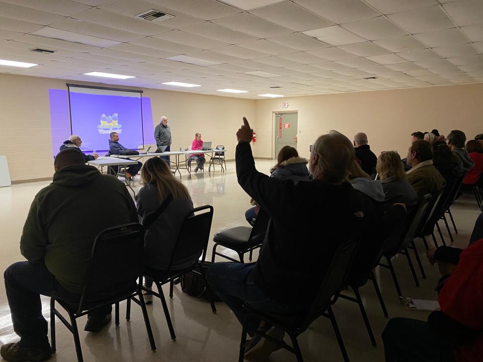 An audience member raises his hand to ask a question Thursday, Jan. 4, 2024, during a Raisin Township Planning Commission meeting on gravel mines.