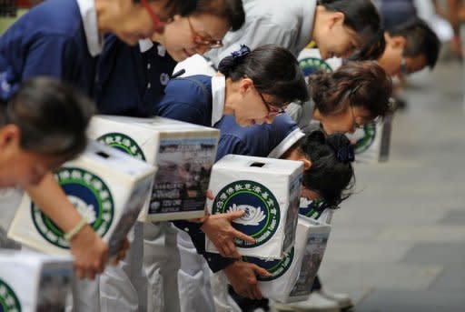 Members of the international non-profit organisation, the Buddhist Tzu Chi Foundation, bow their heads as they collect donations in Sydney