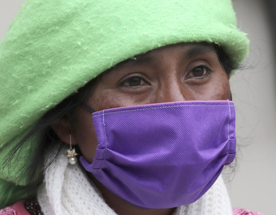 Una mujer indígena con una máscara para evitar el contagio del nuevo coronavirus camina en Cayambe, Ecuador, el miércoles 17 de junio de 2020. (AP Foto/Dolores Ochoa)