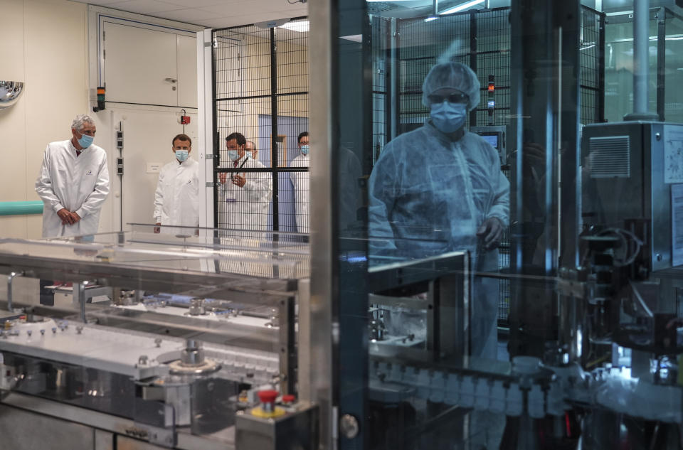 French President Emmanuel Macron listens to a researcher as he visits an industrial development laboratory at French drugmaker's vaccine unit Sanofi Pasteur plant in Marcy-l'Etoile, near Lyon, central France, Tuesday, June 16, 2020.The visit comes after rival pharmaceutical company AstraZeneca this weekend announced a deal to supply 400 million vaccine doses to EU countries, including France. (AP Photo/Laurent Cipriani, Pool)