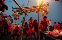 <p>Indian Hindu devotees of the deity Shiva perform a ritual after collecting water from the Ganges river for their ritualistic walk towards Varanasi during the holy month of Shravan, in Allahabad on July 28, 2016. Shravan is considered the holiest month in the Hindu calendar with many religious festivals and ceremonies. </p>