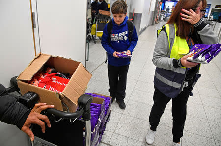 Airport staff distribute chocolates and Christmas elf toys to waiting passengers in the South Terminal building at Gatwick Airport, after the airport reopened to flights following its forced closure because of drone activity, in Gatwick, Britain, December 21, 2018. REUTERS/Toby Melville