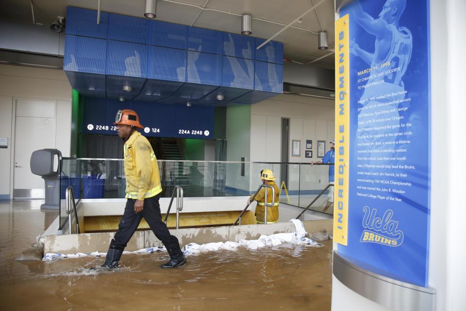 A firefighter walks past a dammed up stairway inside UCLA's Pauley Pavilion sporting arena as water flows from a broken thirty inch water main that was gushing water onto Sunset Boulevard near the UCLA campus in the Westwood section of Los Angeles July 29, 2014. The geyser from the 100-year old water main flooded parts of the campus and stranded motorists on surrounding streets. REUTERS/Danny Moloshok