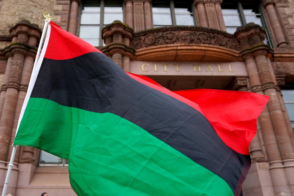 The Black Liberation Flag is carried in front of Cincinnati City Hall as the Juneteenth Flag is raised for the second time in as many years at Cincinnati City Hall, Friday, June 18, 2021. Juneteenth was recognized a federal holiday this week after President Joe Biden signed it into law. Ohio. Gov. Mike DeWine recognized the day as a state holiday, and all state employees received Friday off. 