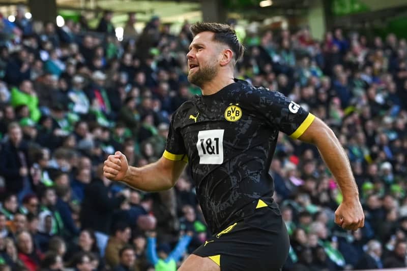 Dortmund's Niclas Fuellkrug celebrates scoring his side's first goal during the German Bundesliga soccer match between VfL Wolfsburg and Borussia Dortmund at the Volkswagen Arena. Swen Pförtner/dpa