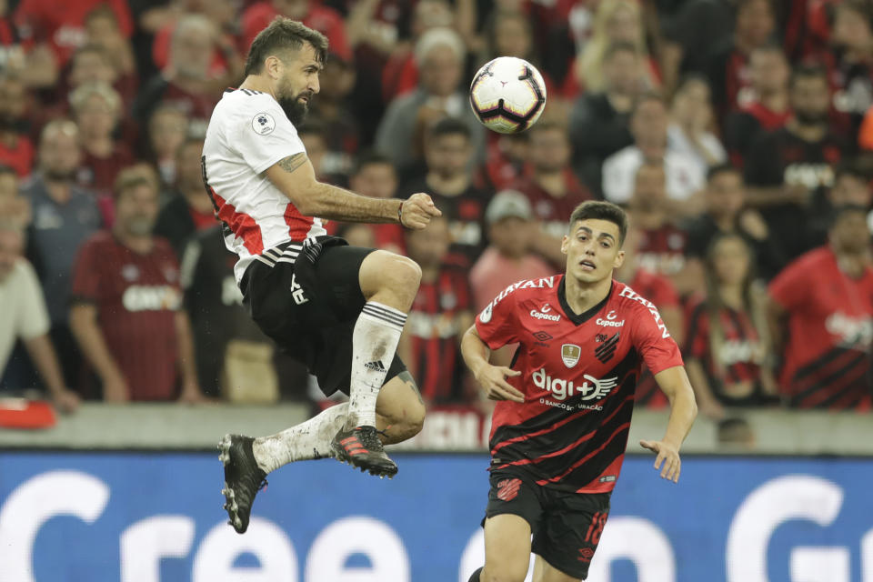 In this Wednesday, May 22, 2019 photo, Lucas Pratto of Argentina's River Plate heads the ball past Leonardo Cittadini of Brazil's Athletico Paranaense during Recopa Sudamericana first leg final soccer match in Curitiba, Brazil. (AP Photo/Andre Penner)