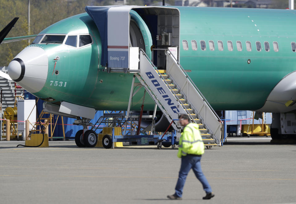 FILE - In this April 26, 2019, file photo a worker walks past a Boeing 737 MAX 8 airplane being built for Oman Air at Boeing's assembly facility in Renton, Wash. Passengers who refuse to fly on a Boeing Max won’t be entitled to compensation if they cancel. However, travel experts think airlines will be very flexible in rebooking passengers of giving them refunds if they’re afraid to fly on a plane that has crashed twice. (AP Photo/Ted S. Warren, File)