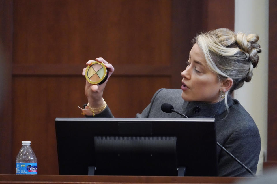 Actor Amber Heard testifies and displays a makeup kit in the courtroom at the Fairfax County Circuit Courthouse in Fairfax, Va., Monday, May 16, 2022. Actor Johnny Depp sued his ex-wife Amber Heard for libel in Fairfax County Circuit Court after she wrote an op-ed piece in The Washington Post in 2018 referring to herself as a "public figure representing domestic abuse." (AP Photo/Steve Helber, Pool)