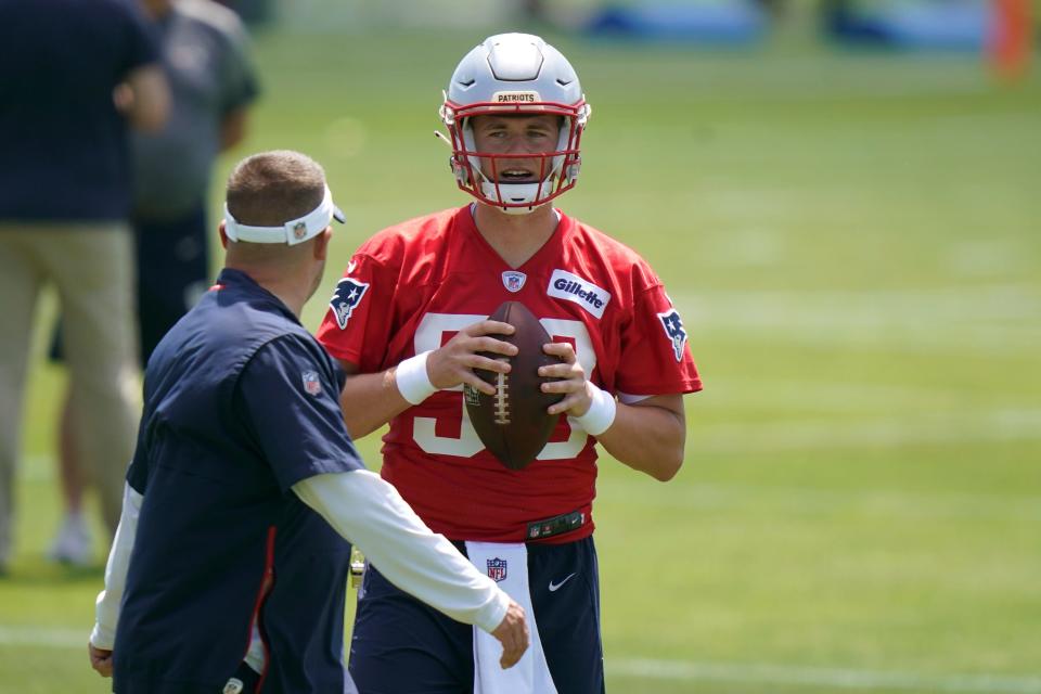 New England Patriots quarterback Mac Jones speaks with offensive coordinator Josh McDaniels during NFL football practice in Foxborough on Thursday.