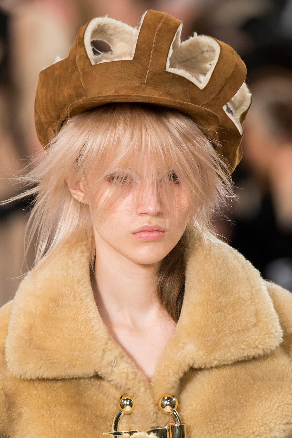 Model wears a brown suede and shearling cut-out beret at the Maison Margiela Fall/Winter 2017 show.