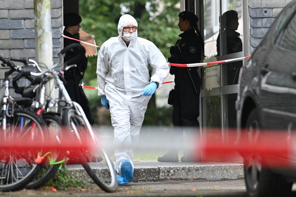 An investigator dressed in protective gear leaves the crime scene where the children were found.