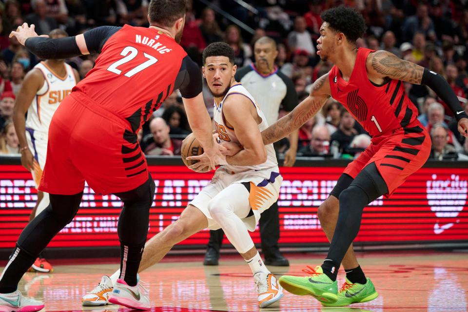 Oct 21, 2022; Portland, Oregon, USA; Phoenix Suns guard Devin Booker (1) is double-teamed by Portland Trail Blazers center Jusuf Nurkic (27) and guard Anfernee Simons (1) during the first half at Moda Center.