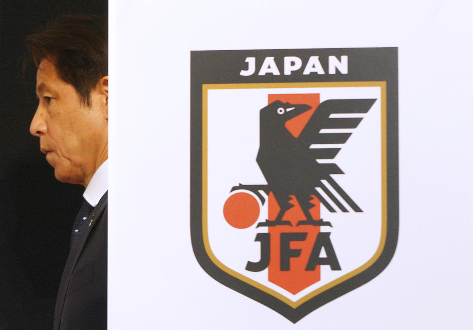 El seleccionador japonés Akira Nishino detrás del escudo de la “Japan Football Association”, durante una rueda de prensa en Tokio. / Foto: AP / Eugene Hoshiko.