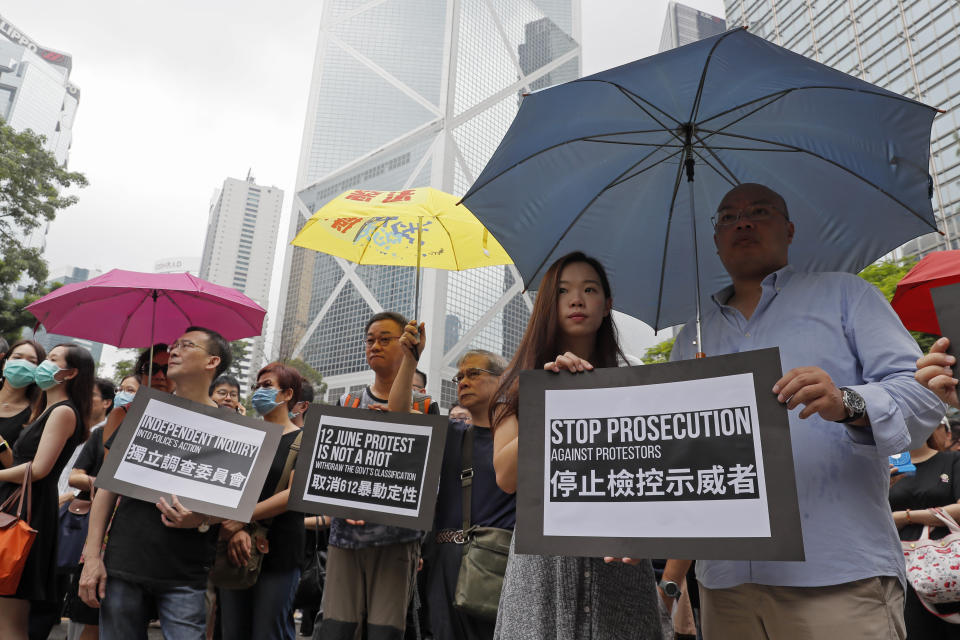 Hundreds of accountants march at Chater Garden, in Hong Kong, Friday, Aug. 23, 2019. Protesters demand to fully withdraw the extradition bill and set up an independent committee to investigate the use of force by Hong Kong police. (AP Photo/Kin Cheung)