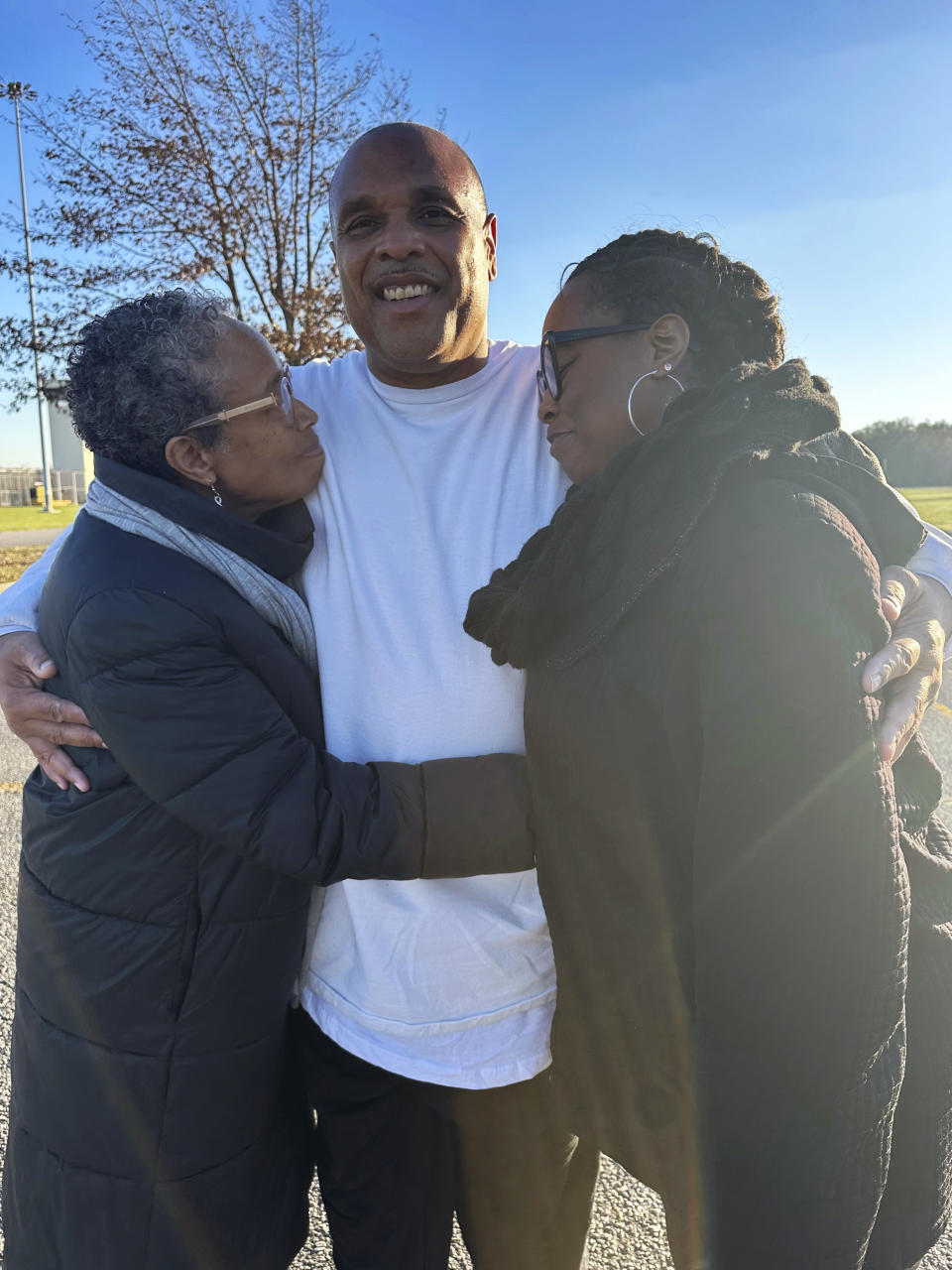 In this photo provided by Laura Nirider, Brian Beals, center, who was exonerated on a murder charge and released from a downstate prison after 35 years behind bars, hugs his sister Pattilyn Beals, left, and niece Tamiko Beals outside Robinson Correctional Institution, in Robinson, Ill., on Tuesday, Dec. 12, 2023. (Laura Nirider via AP)