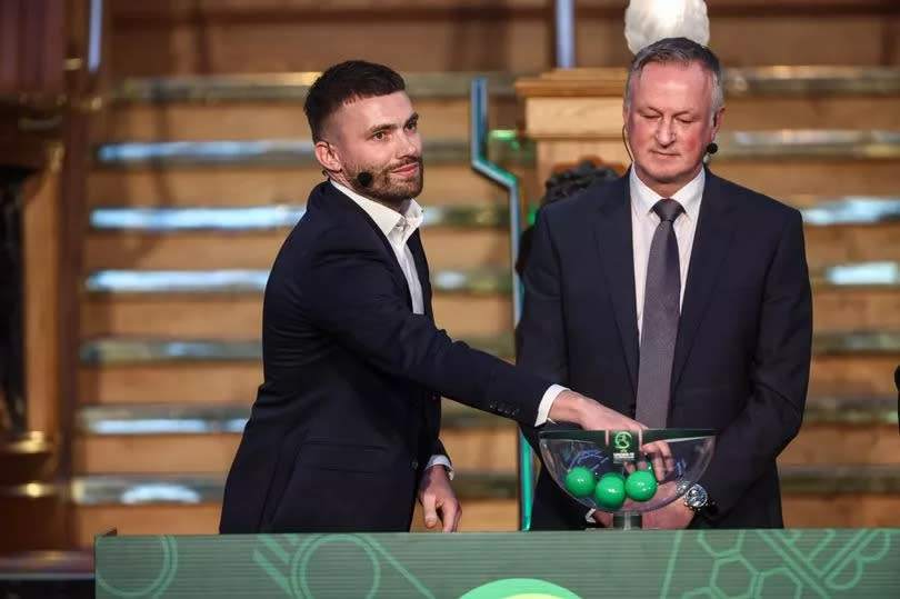 A picture of Stuart Dallas making the draw alongside Northern Ireland boss Michael O'Neill