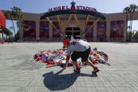 Miguel Gonzalez places a hat on a memorial for Los Angeles Angels pitcher Tyler Skaggs at Angel Stadium in Anaheim, Calif., Tuesday, July 2, 2019. The 27-year-old left-hander died in his Texas hotel room, where he was found unresponsive Monday afternoon. (AP Photo/Chris Carlson)