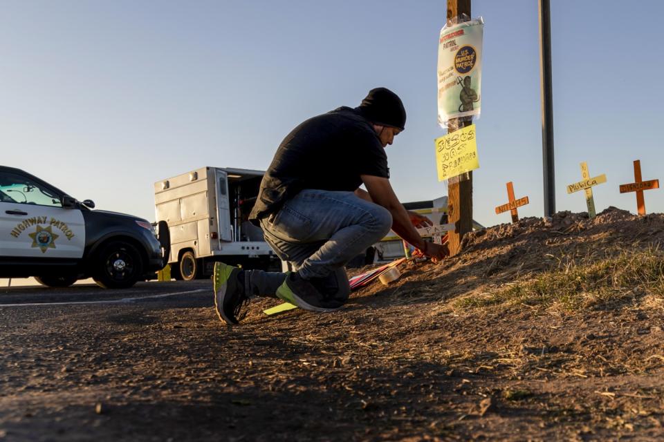 Activist Hugo Castro places crosses at the scene of the fatal SUV crash near the border