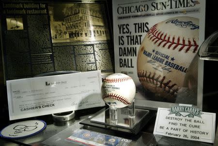 The baseball bobbled by Steve Bartman in foul territory during game six of the Cubs playoff game with the Florida Marlins October 14, 2003 "lays in state" at Harry Caray's Restaurant in Chicago, Illinois February 26, 2004. REUTERS/Allen Fredrickson