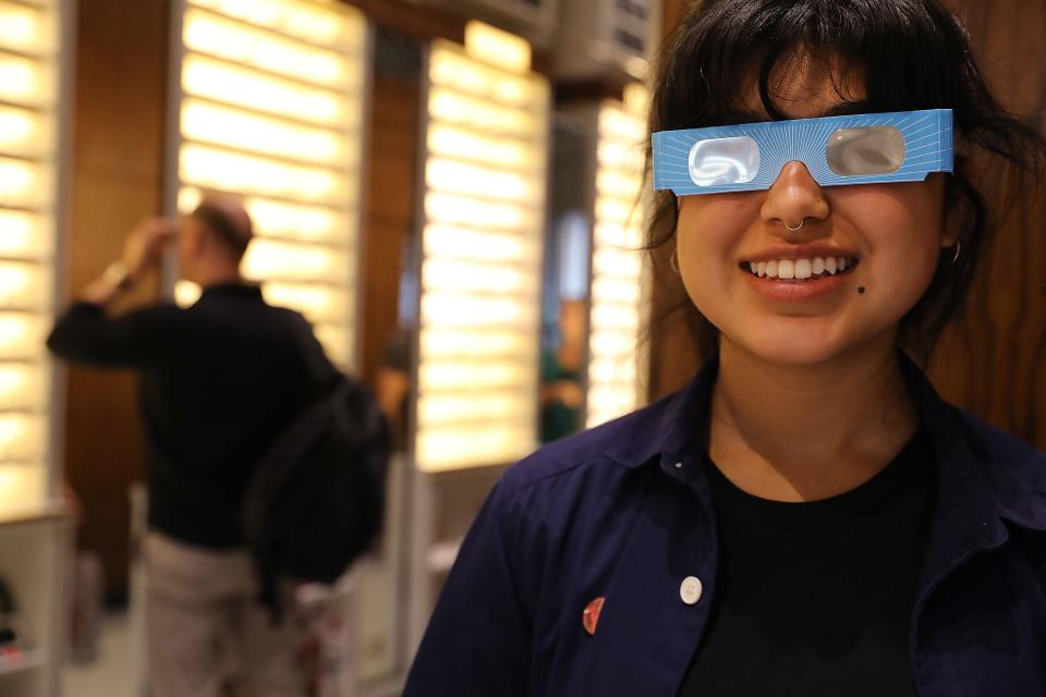 Warby Parker employee Karolyna Landin poses with a pair of solar eclipse glasses that the eyeglass store gave out for the 2017 ecl;ipse.
