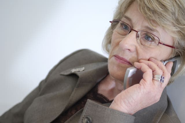 mature businesswoman talking on mobile phone looking concerned