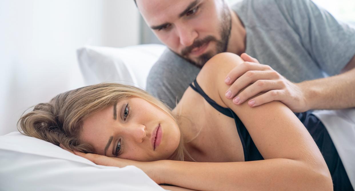 woman faces away from man in bed and looks sad as study reveals biggest bedroom turn-offs. (Getty Images)
