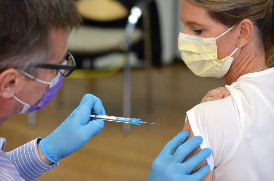 James Donnelly, R.N., at left, gives a COVID-19 vaccination to Laura Bednarski, R.N., in December 2020. Donnelly is the chief quality and nursing officer at UPMC Hamot.