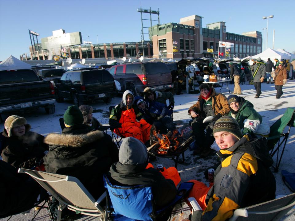 Green Bay Packers fans brave the frigid weather in the parking lot at Lambeau Field.