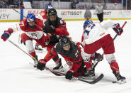 Canada's Emma Maltais (27) battles Czechia's Klara Hymlarova (12) for the puck during the second period of a hockey match at the IIHF Women's World Championships in Utica, N.Y., Sunday, April 7, 2024.(Christinne Muschi/The Canadian Press via AP)