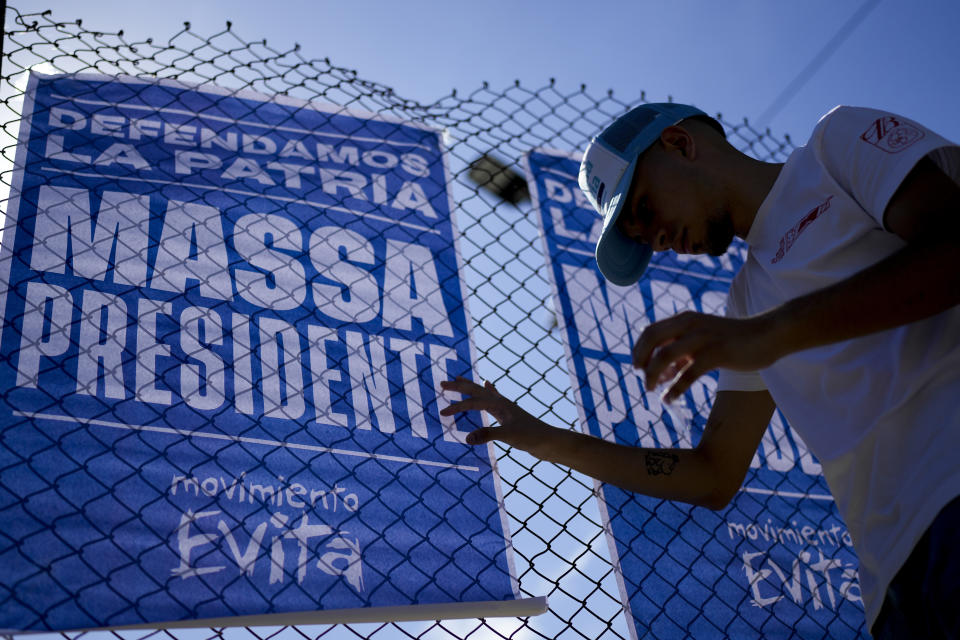 A man hangs a campaign sign promoting Economy Minister Sergio Massa, the ruling party’s presidential candidate, on the outskirts of Buenos Aires, Argentina, Wednesday, Nov. 8, 2023. As Argentina heads for a presidential Nov. 19 runoff election, the decades-old populist movement known as Peronism has Massa working overtime to keep once-steadfast supporters from straying to his opponent, right-wing populist Javier Milei. (AP Photo/Natacha Pisarenko)