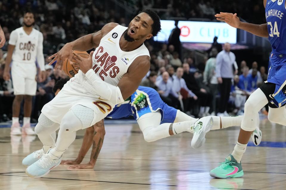 Cleveland Cavaliers' Donovan Mitchell is fouled by Milwaukee Bucks' George Hill during the first half of an NBA basketball game Wednesday, Nov. 16, 2022, in Milwaukee. (AP Photo/Morry Gash)